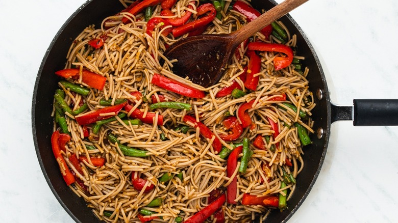 soba noodles and peppers in pan