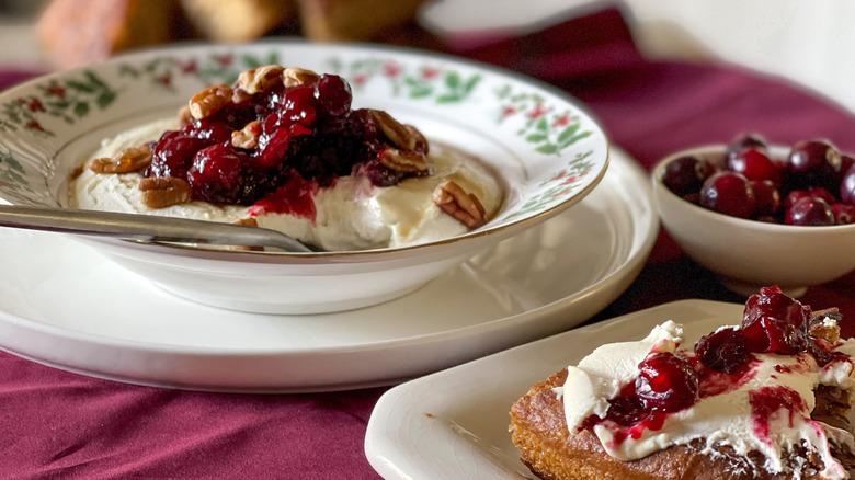 cranberry-cheese spread in a holly-patterned bowl on a burgundy napkin