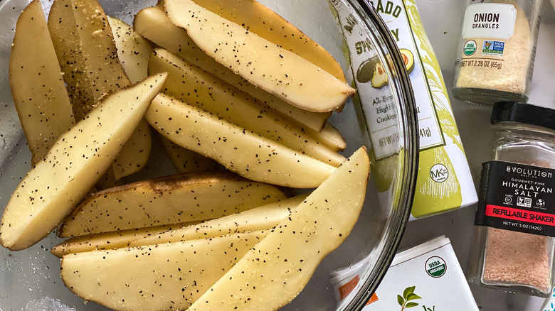 Seasoned potato wedges placed in a bowl.