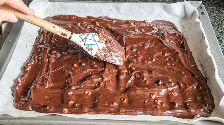 Spreading brownie mix at the bottom of the pan