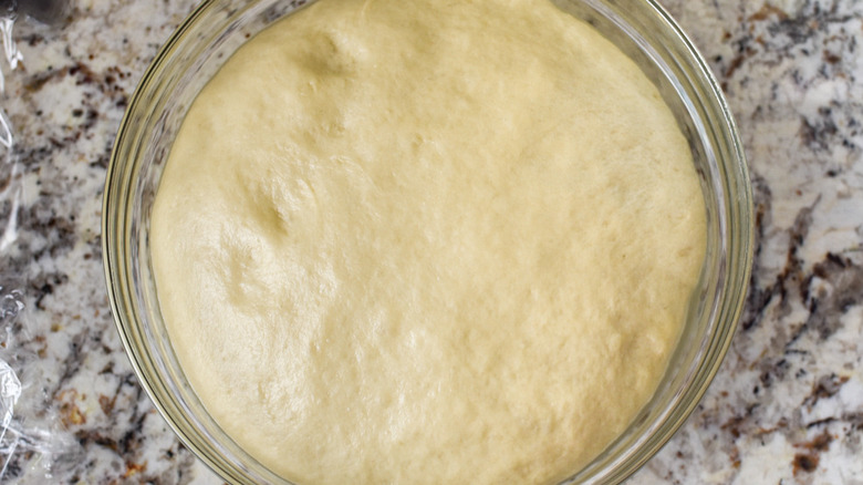 risen doughnut dough in bowl