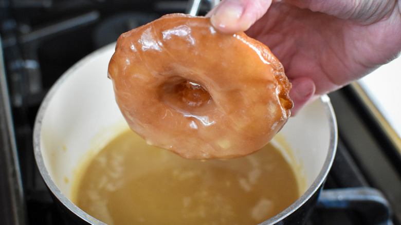 hand holding glazed doughnut