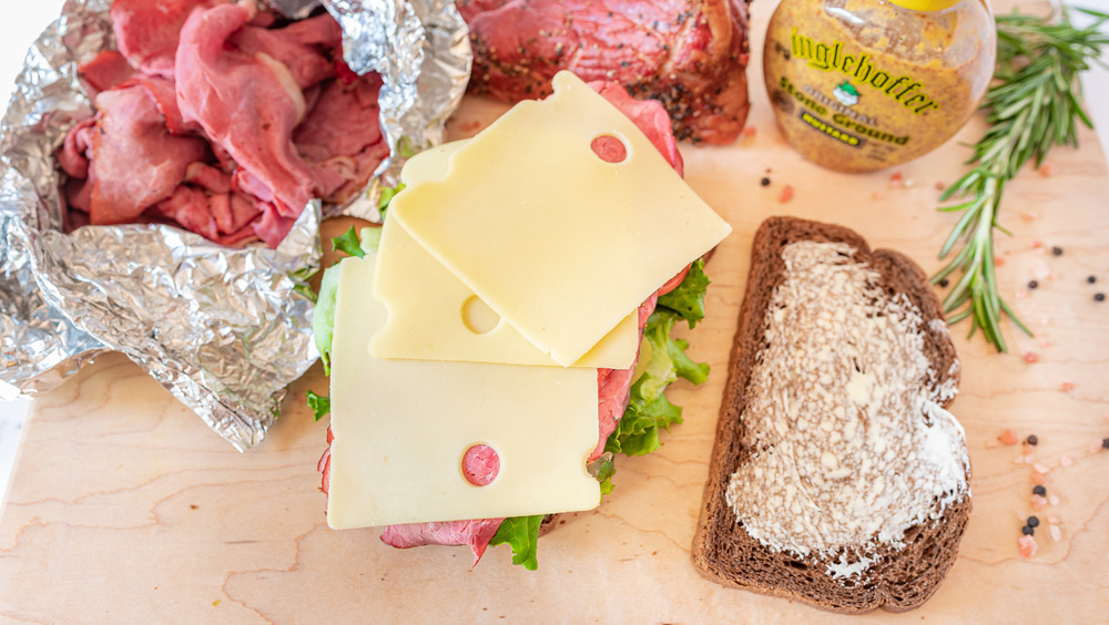 stacking a homemade hot pastrami sandwich