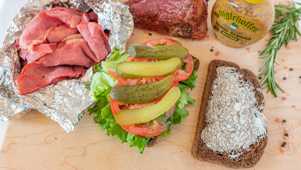 stacking a homemade hot pastrami sandwich