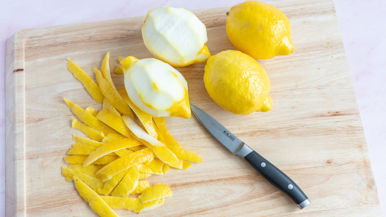 peeling lemons on cutting board