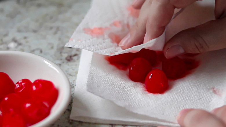 maraschino cherries in a bowl and on a paper towel being patted dry