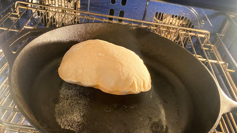 Pita bread cooking in a cast iron pan