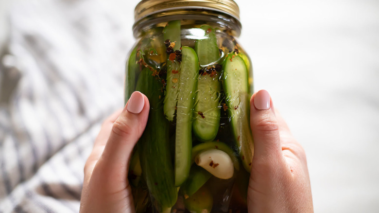 hands holding pickle jar