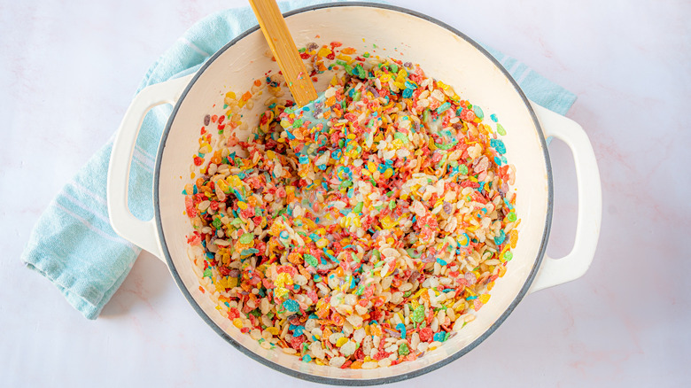 mixing cereal and marshmallows for homemade rice crispy treats with Fruity Pebbles