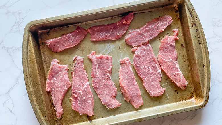 sliced beef on baking sheet