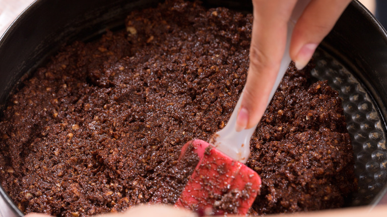 pressing cheesecake crust into pan