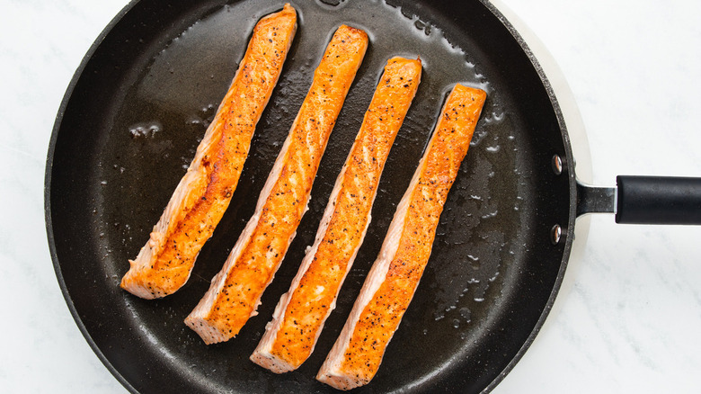 Salmon cooking in pan