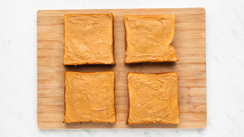 Four slices of milk bread spread with peanut butter