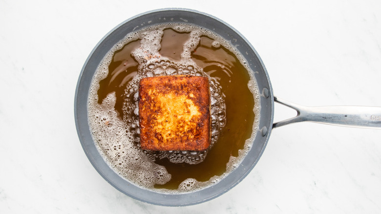 Stuffed French toast frying in pan