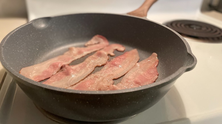 raw bacon in skillet