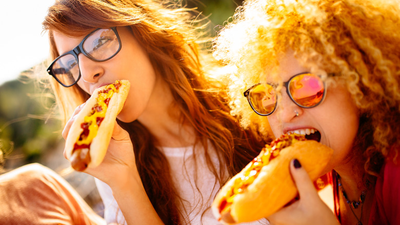 people biting hot dogs