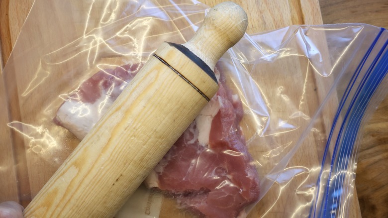 pounding meat with rolling pin