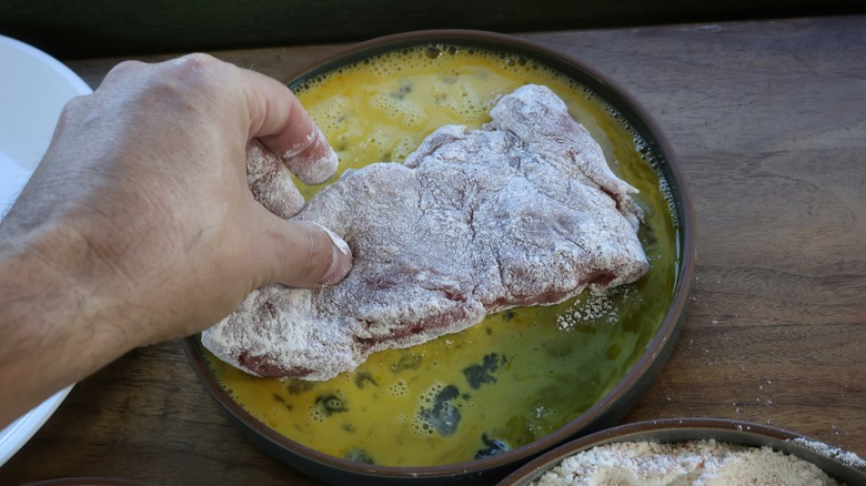 dipping floured pork in egg