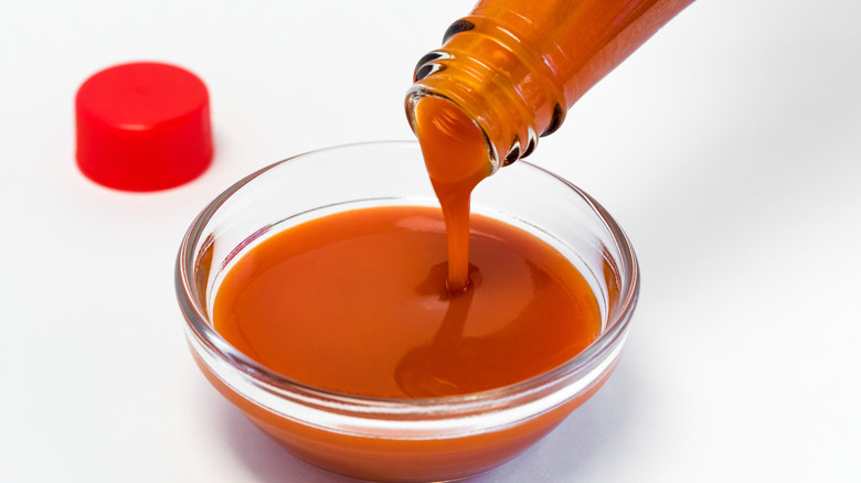 Pouring hot sauce into a bowl