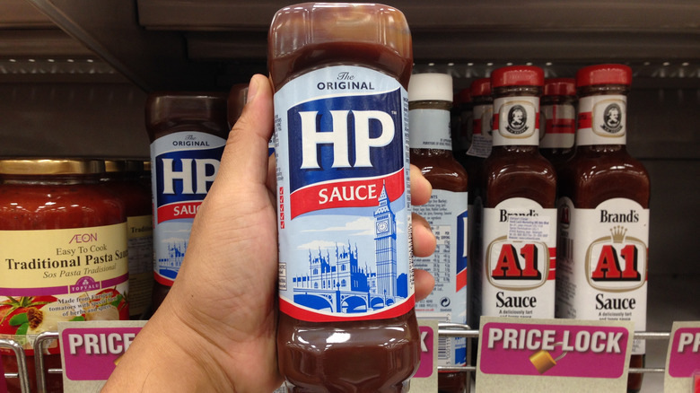 Hand holding H.P. sauce bottle