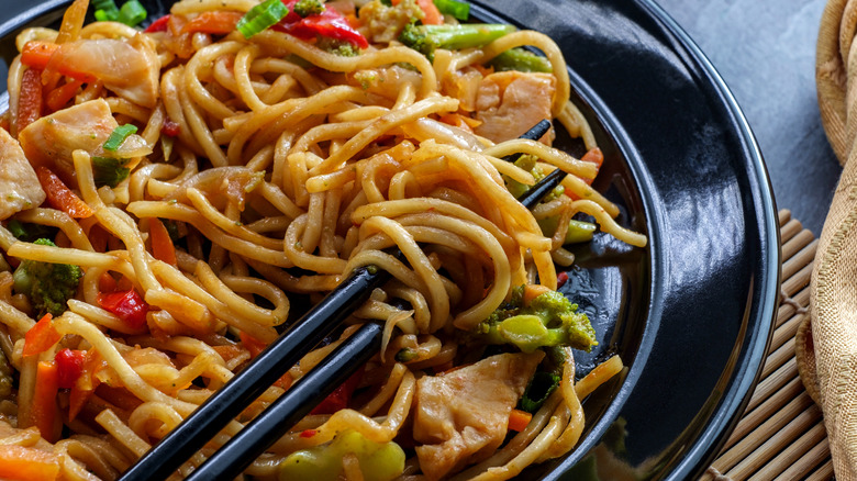 Chop suey in white plate on black table