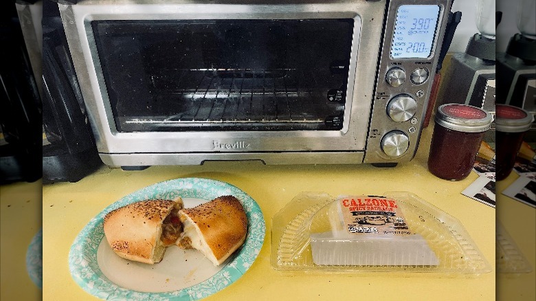 An Aldi calzone sitting in front of a toaster oven.