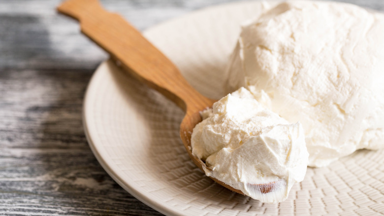 Mascarpone and wooden spreader on plate