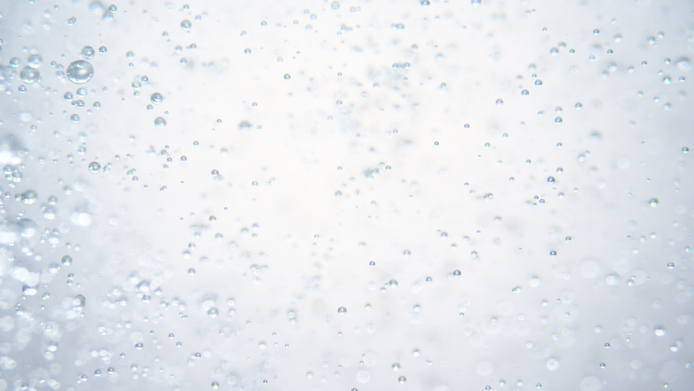 Glass of fizzy water on table