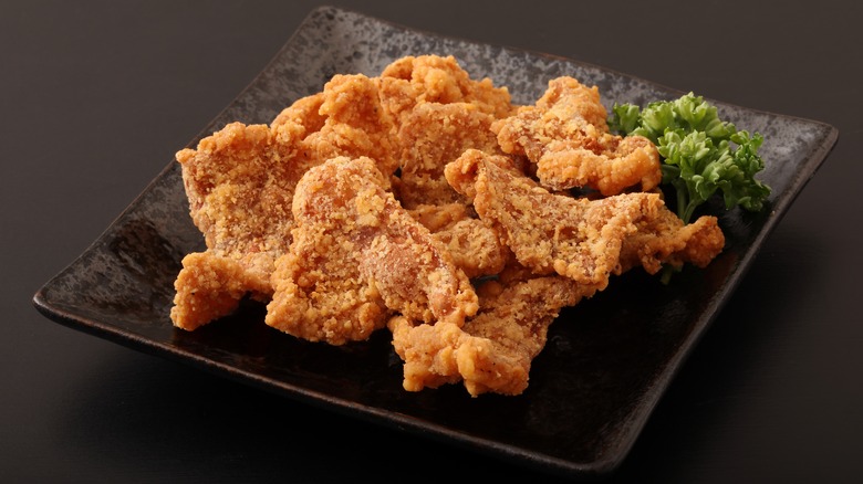 Fried chicken skin on a plate with garnish