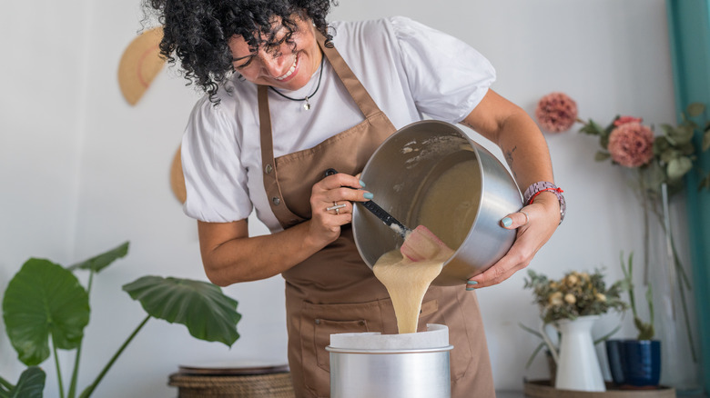 woman pouring cake batter into pan