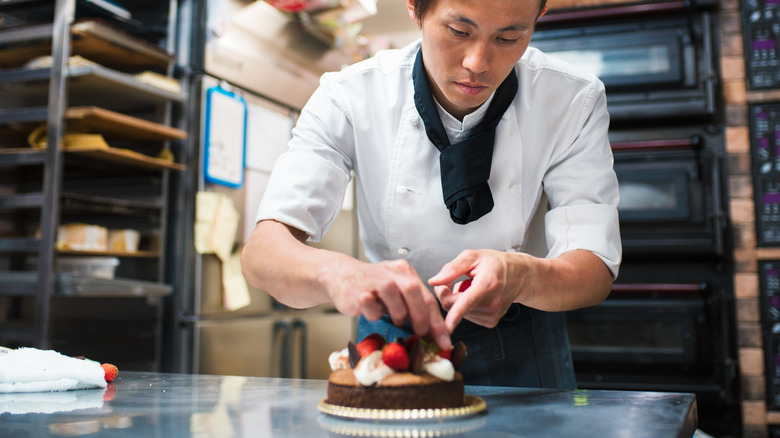 baker decorating cake