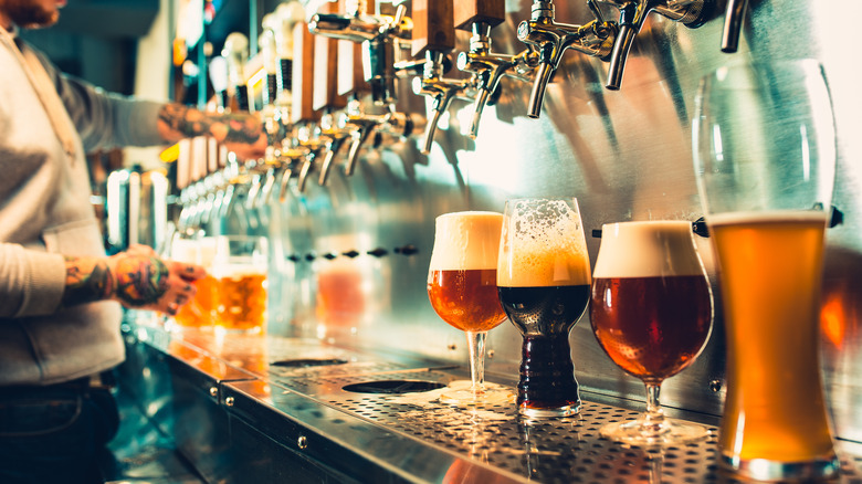 Beer lined up under silver taps