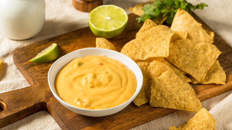 tray of tortilla chips and nacho cheese sauce