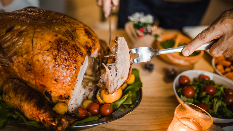 person carving a turkey