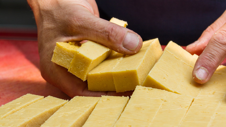 hands grabbing uncooked chickpea fries