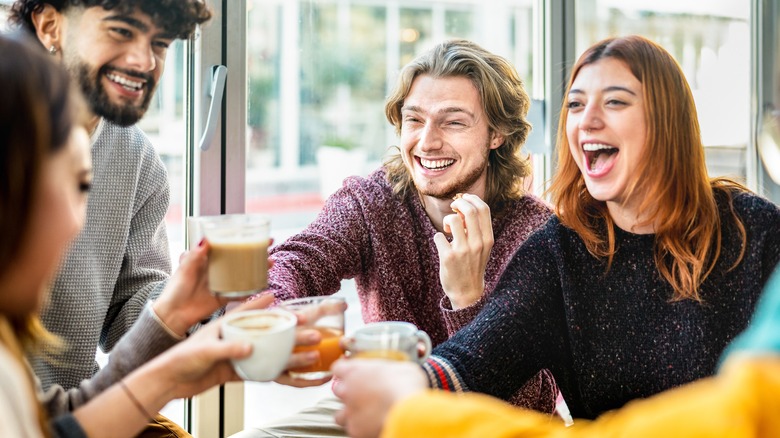 friends toasting lattes at coffeehouse