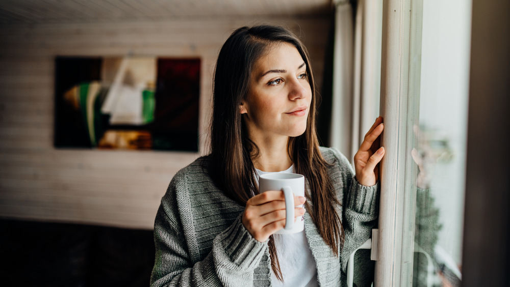 Person drinking coffee in a white mug