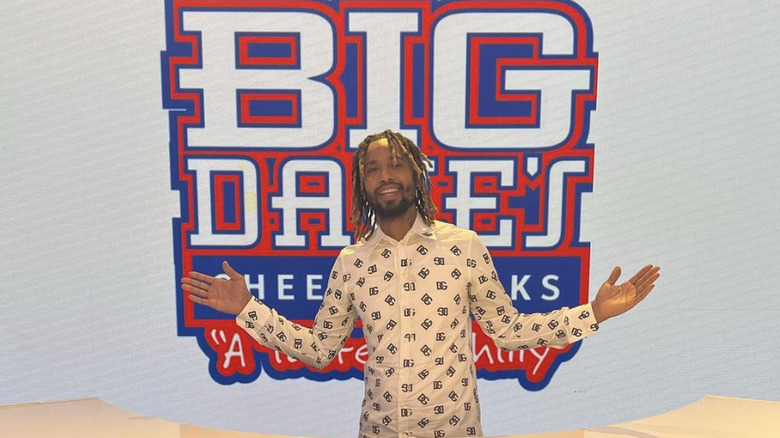 Derrick Hayes posing in front of Big Dave's sign 