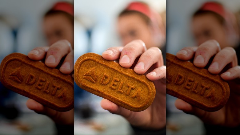 Hand holding Delta-branded Biscoff cookie