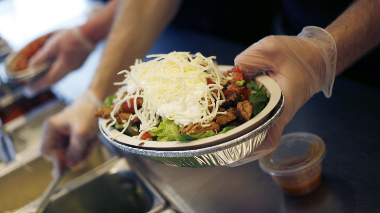 Chipotle worker making burrito bowl