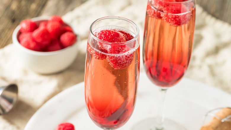 two glasses of sparkling rose with raspberries