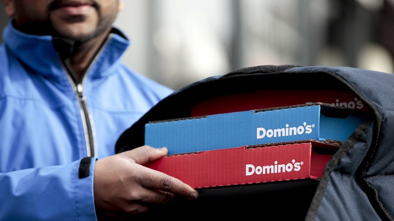 A Domino's delivery man delivering pizzas