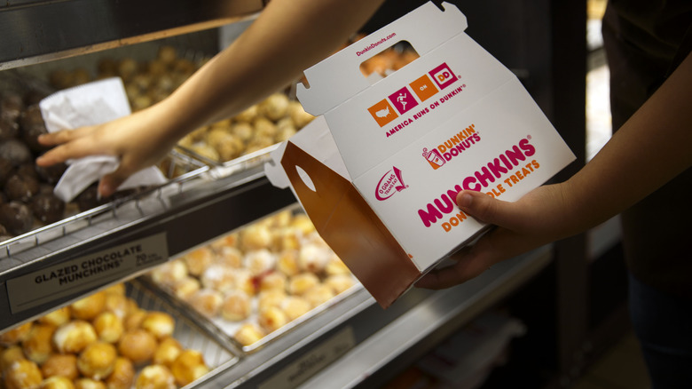 Dunkin employee putting donut holes in a box