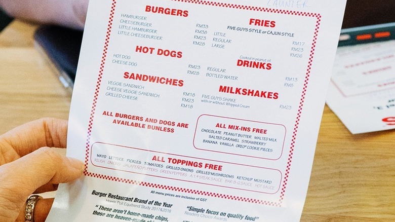 Person holding Five Guys menu