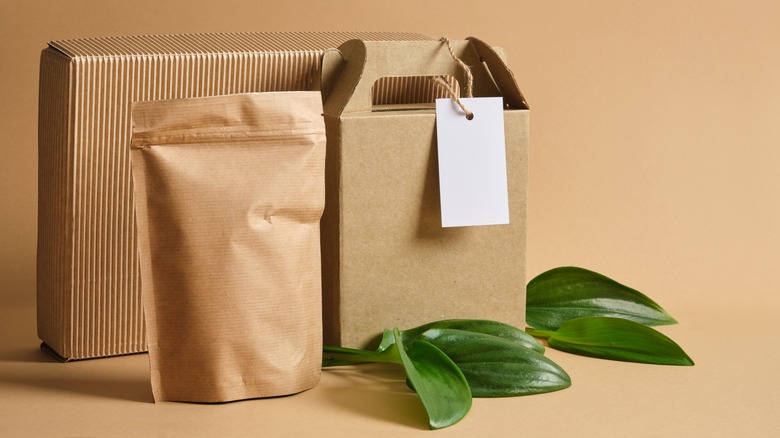 Label-less brown bags and boxes beside green leaves