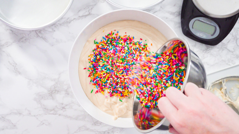 pouring sprinkles in cake batter