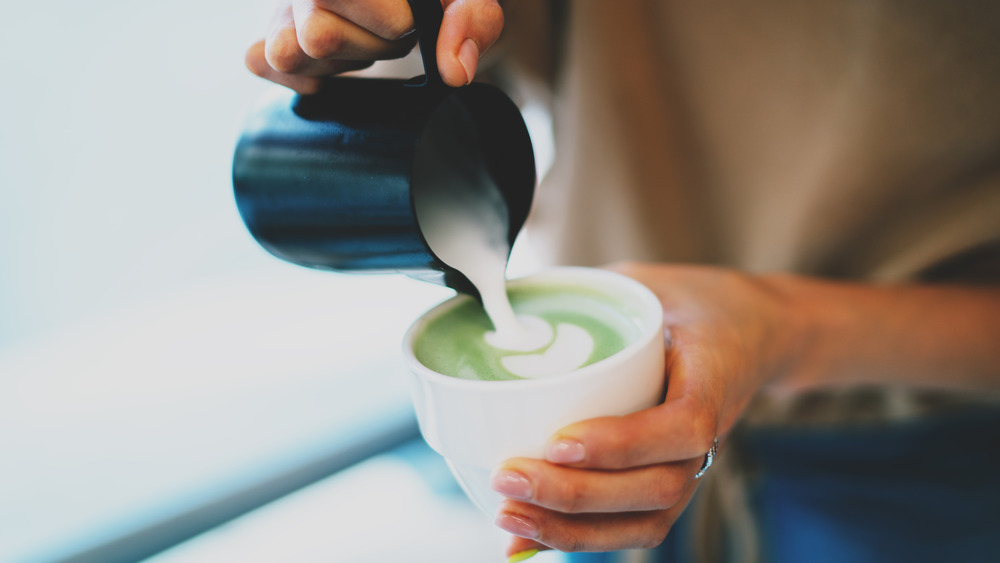 Woman making a matcha latte