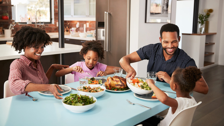 Family sitting around a table eating a meal