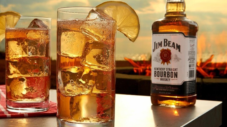 Jim Beam highball cocktails and bourbon bottle at sunset