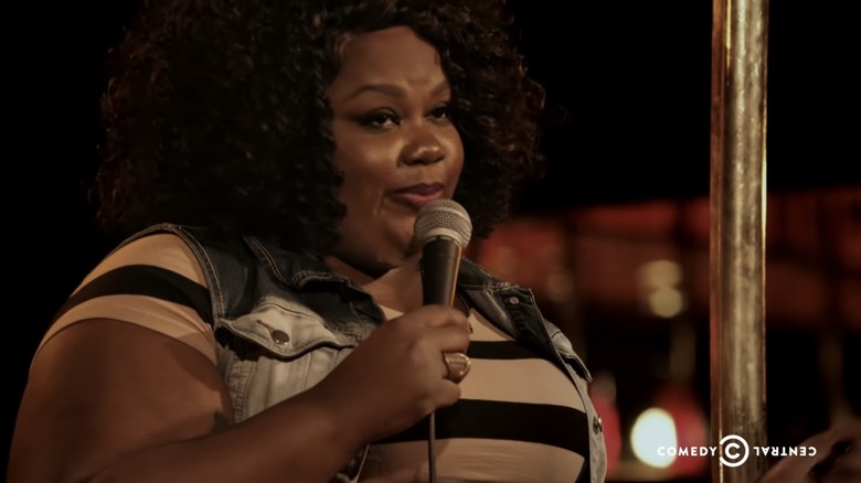 Nicole Byer holding microphone